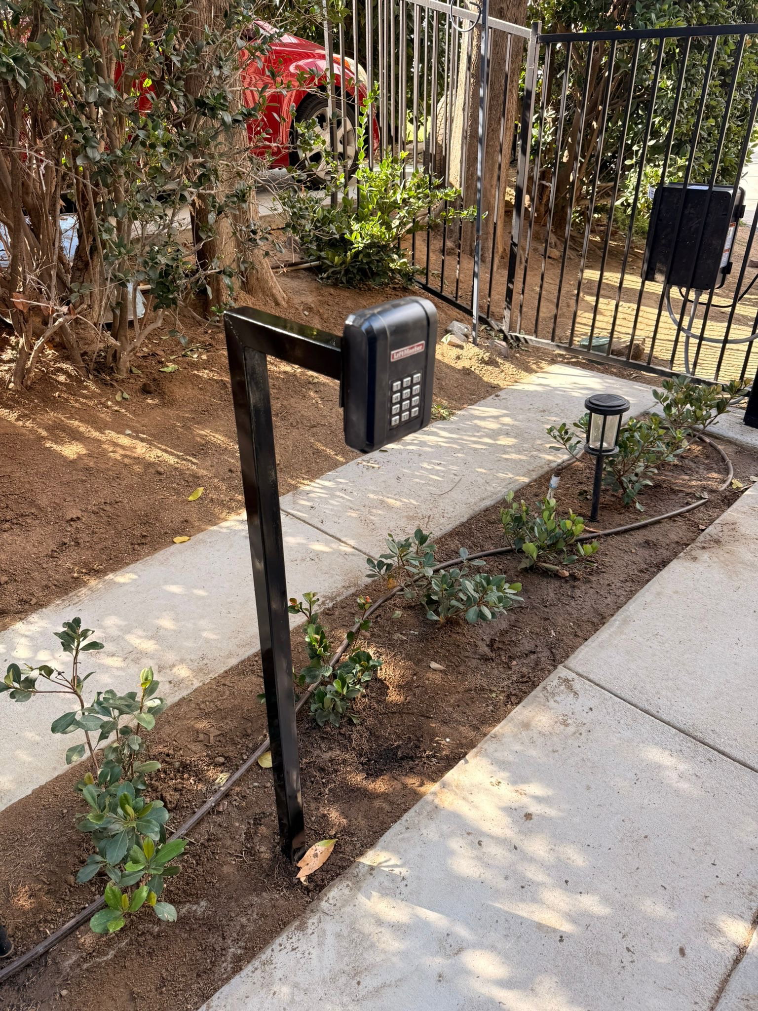 A driveway gate access-control intercom and keypad pedestal installed in the Inland Empire