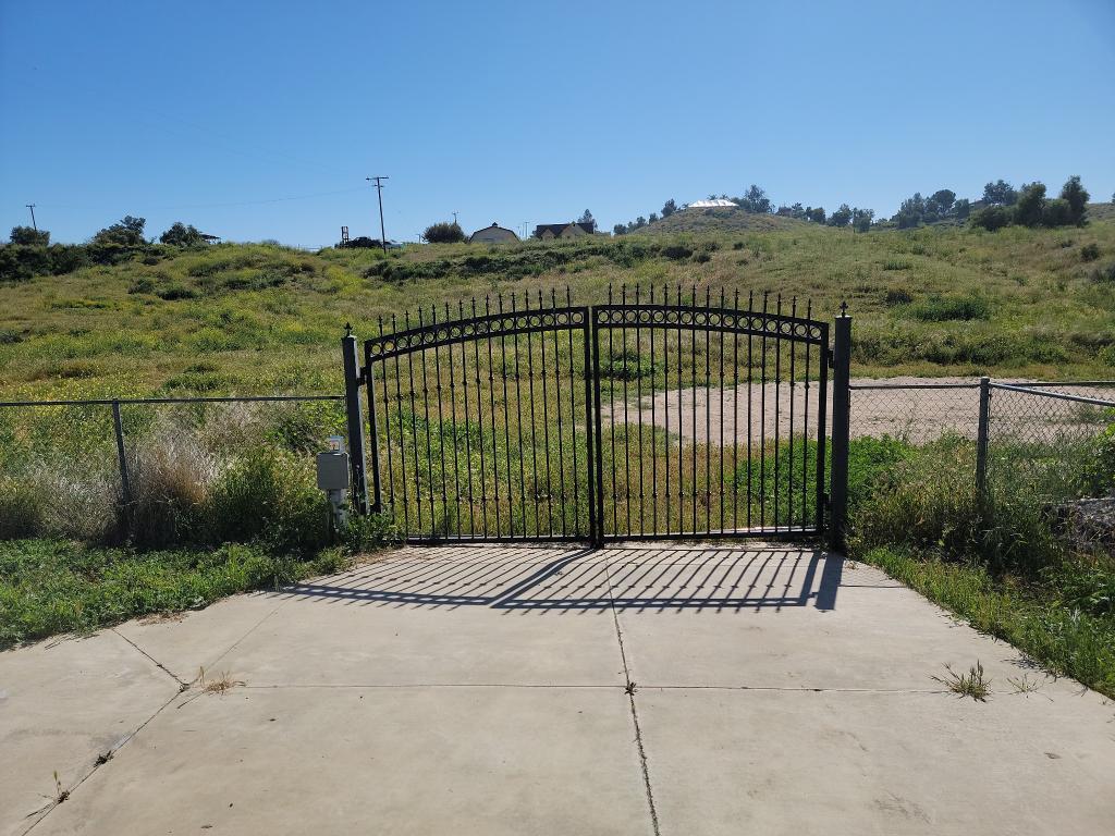 A black ornamental wrought-iron driveway gate repaired and welded in the Inland Empire