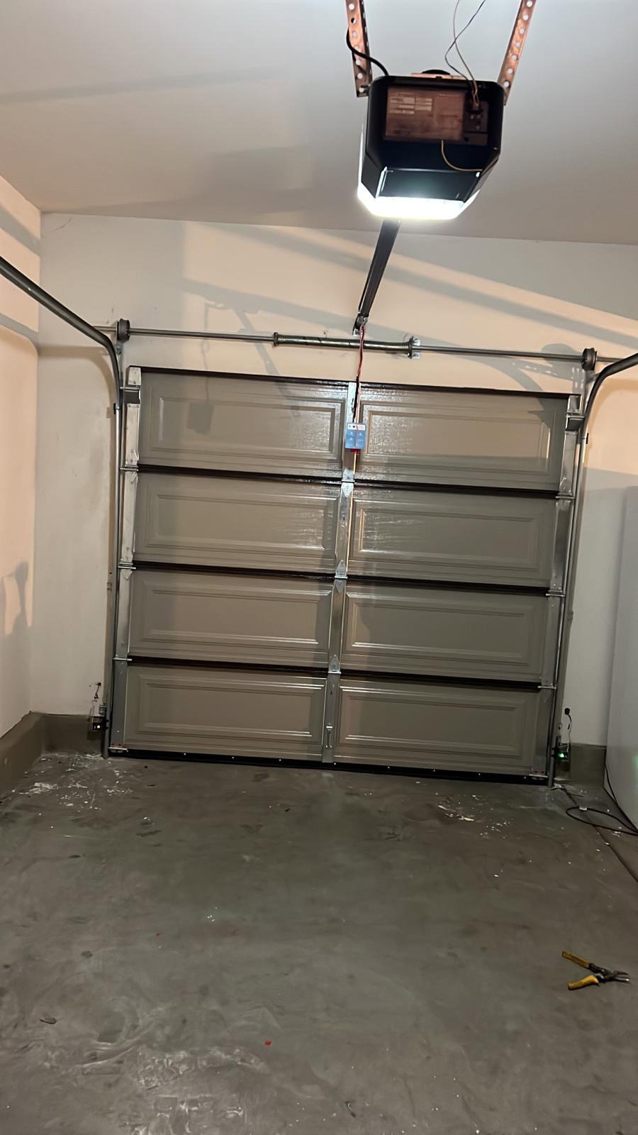 A modern garage interior with a smart Wi-Fi garage door opener installed in Riverside