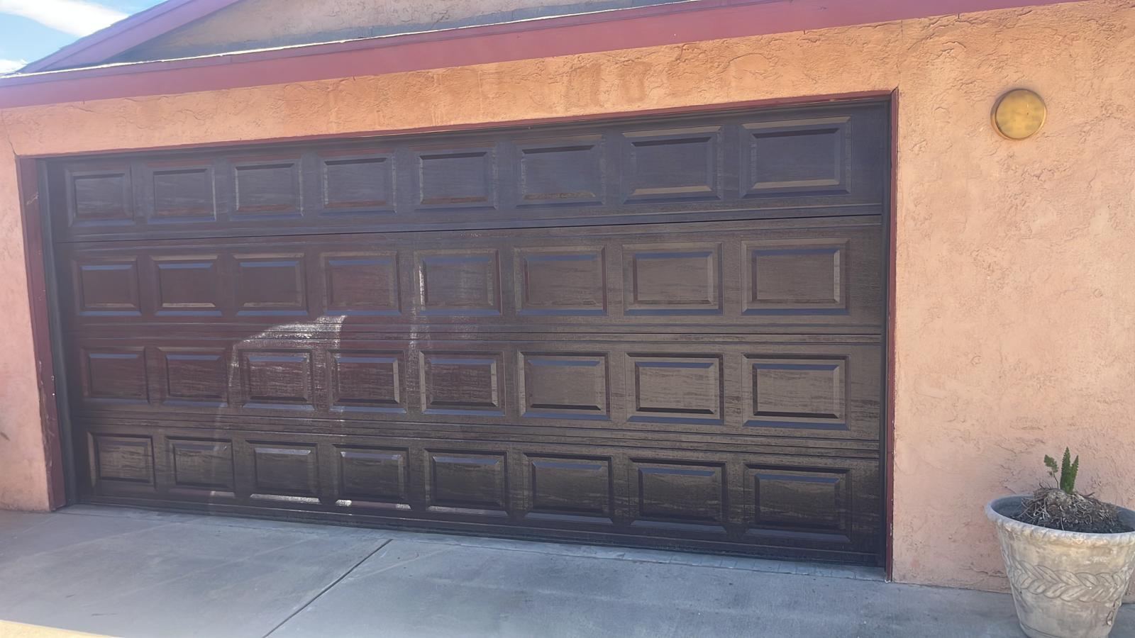 A double-wide garage door with a replaced, color-matched section in the Inland Empire