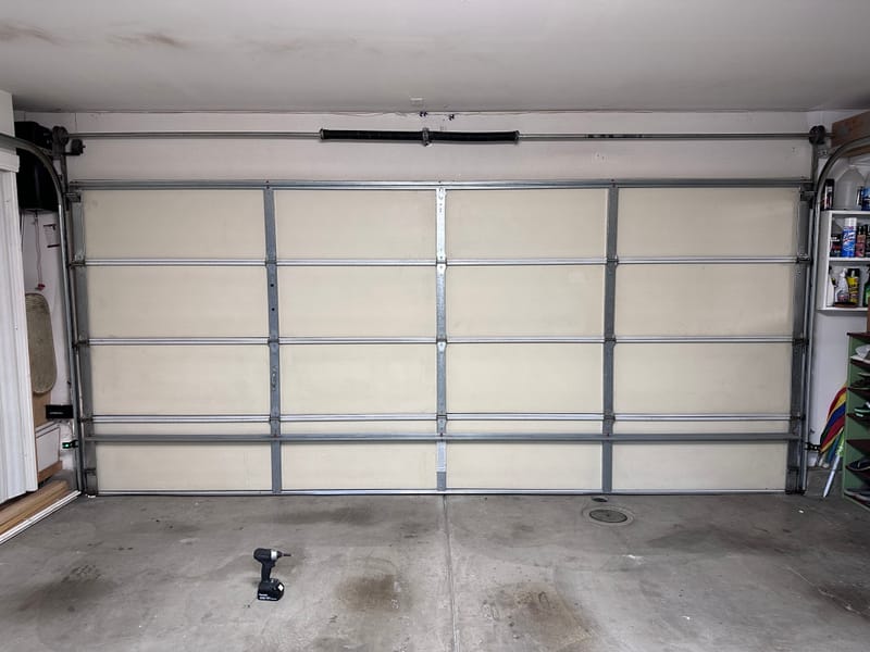 A reinforcement strut bar installed across a garage door panel